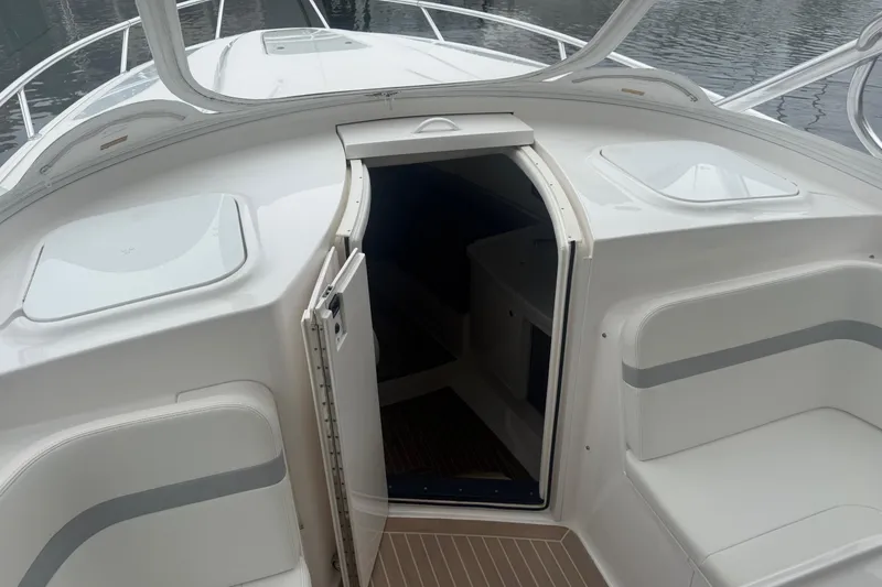 Slide: The Image of 2021 Intrepid 409 Valor boat interior with open storage compartment and wooden flooring. - 23
