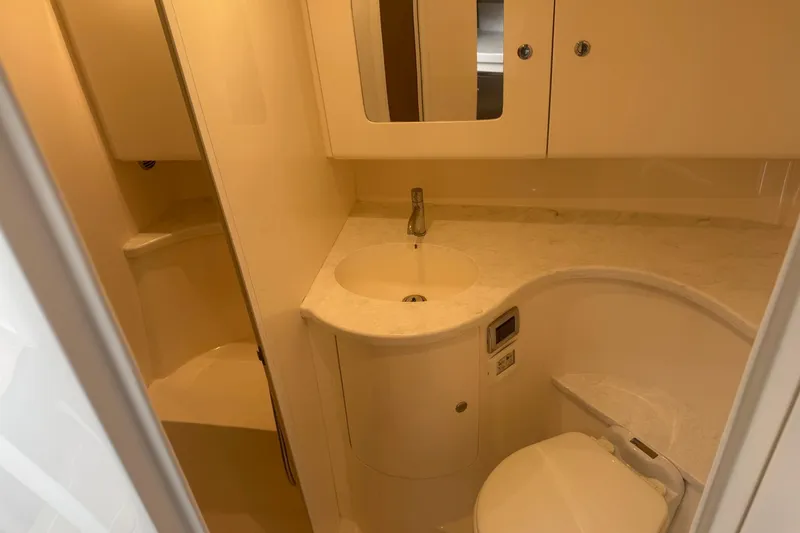 Slide: The Image of 2021 Intrepid 409 Valor yacht bathroom with sink, toilet, and storage cabinets. - 33