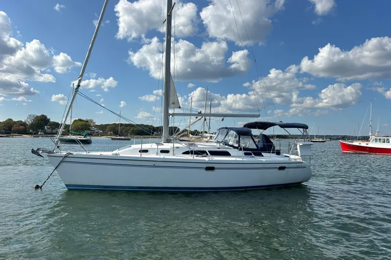 The Image of 2004 Catalina 350 sailboat anchored on calm water under a partly cloudy sky. - 0