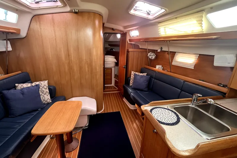 Slide: The Image of Interior of a 2004 Catalina 350 sailboat with cozy seating and wooden finishes. - 1