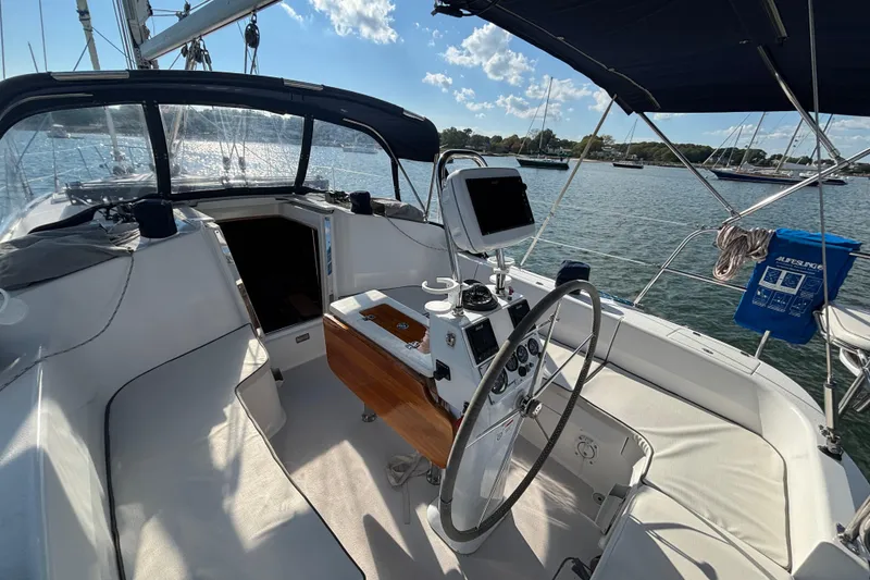 Slide: The Image of 2004 Catalina 350 sailboat cockpit with steering wheel, navigation equipment, and seating, docked on a sunny day. - 22