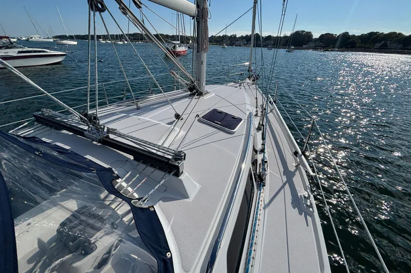 Slide: The Image of 2004 Catalina 350 sailboat on sparkling water, showcasing deck and rigging. - 25