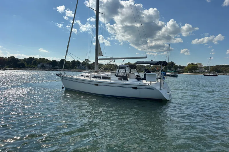 Slide: The Image of Sailboat Catalina 350, 2004 model, anchored on a sunny day with scenic shoreline. - 3