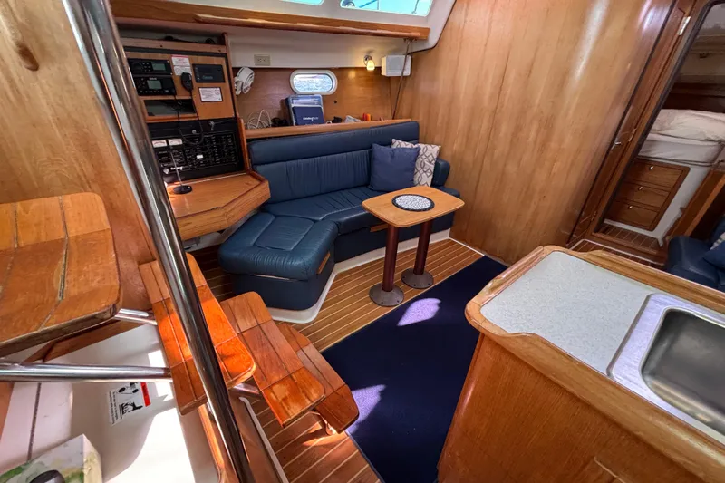 Slide: The Image of Interior of 2004 Catalina 350 sailboat with cozy seating and wooden finishes. - 5