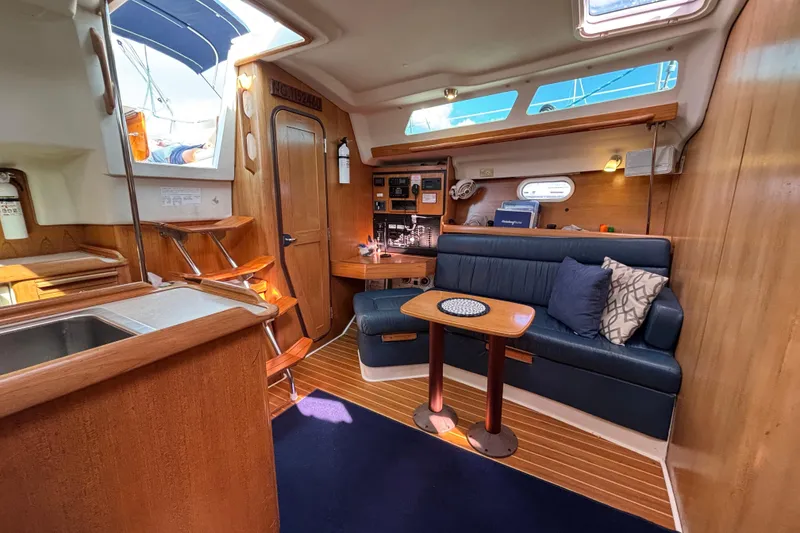 Slide: The Image of Interior of a 2004 Catalina 350 sailboat with cozy seating and wooden finishes. - 8