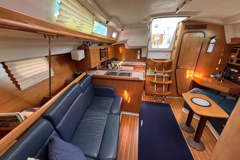 Slide: The Image of Interior of a 2004 Catalina 350 sailboat with cozy seating and a compact kitchen. - 9
