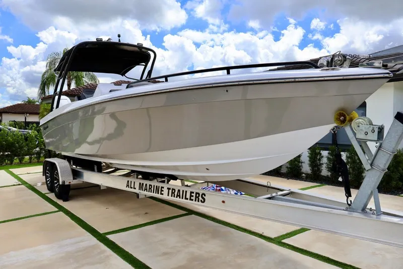 Slide: The Image of 2008 Renegade 29CC boat on trailer, parked outdoors under a cloudy sky. - 2