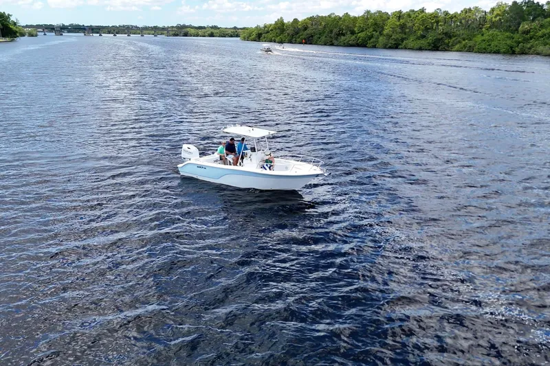 Slide: The Image of 2009 Sea Fox 230 Center Console boat cruising on a scenic river with lush greenery. - 2