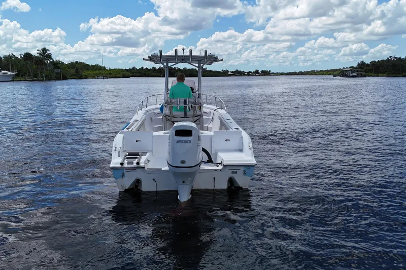 Slide: The Image of 2009 Sea Fox 230 Center Console boat on calm water under a cloudy sky. - 3