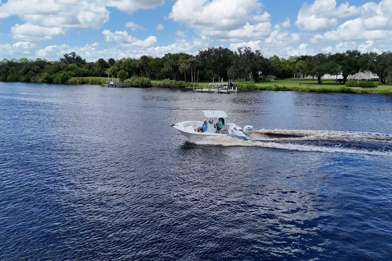 Slide: The Image of 2009 Sea Fox 230 Center Console boat cruising on a scenic river under a blue sky. - 8