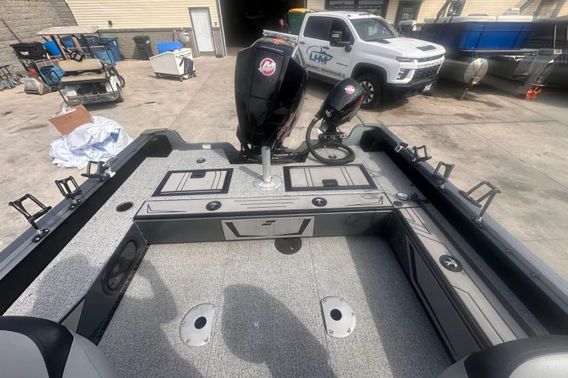 Slide: The Image of 2025 Starcraft Delta 188 DC Pro boat interior with motor, parked near a white truck. - 22