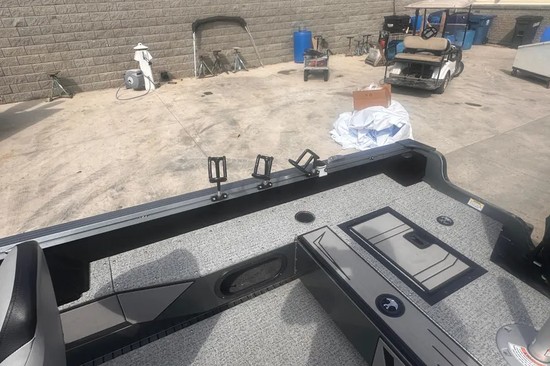 Slide: The Image of 2025 Starcraft Delta 188 DC Pro boat interior with rod holders and storage compartments. - 23