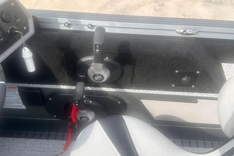 Slide: The Image of Control panel of 2025 Starcraft Delta 188 DC Pro boat with throttle levers and switches. - 25