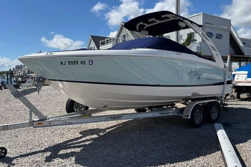 Slide: The Image of 2023 Regal LX4 boat on trailer, parked outdoors under blue sky. - 1