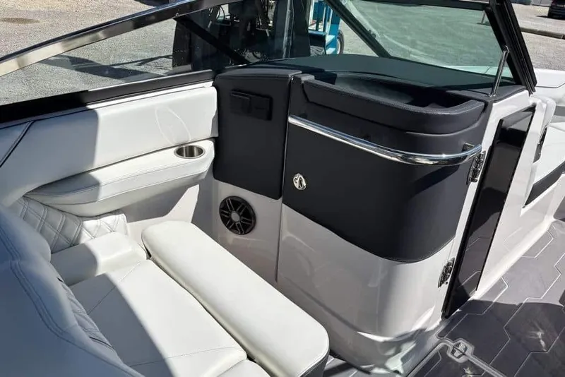 Slide: The Image of 2023 Regal LX4 boat interior with white seating, cup holder, and speaker. - 5