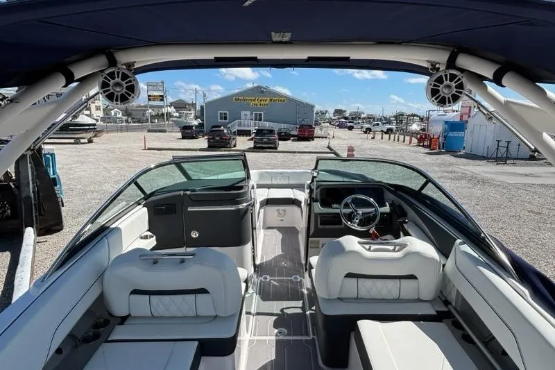Slide: The Image of Interior view of 2023 Regal LX4 boat at a marina, showcasing seating and dashboard. - 8