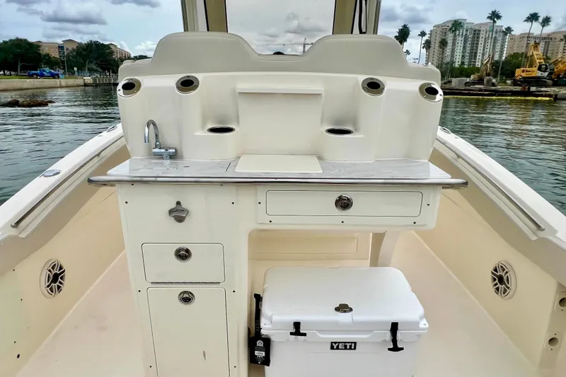 Slide: The Image of 2026 Scout 288 LXF boat interior with sink, storage, and Yeti cooler. - 21
