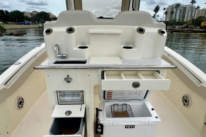 Slide: The Image of 2026 Scout 288 LXF boat with sink, storage, and Yeti cooler on deck. - 22