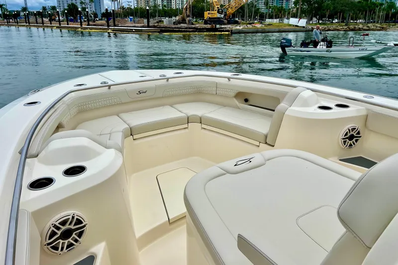 Slide: The Image of 2026 Scout 288 LXF boat interior with spacious seating and cup holders on calm water. - 30