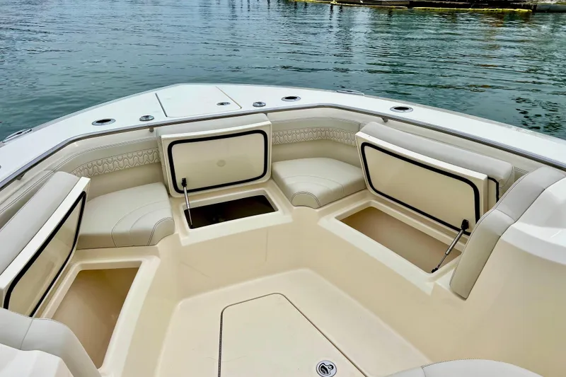 Slide: The Image of 2026 Scout 288 LXF boat interior with open storage compartments and cushioned seating. - 31