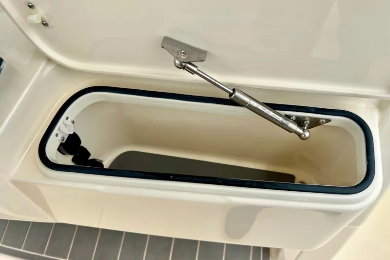 Slide: The Image of Open storage compartment on 2026 Scout 288 LXF boat, featuring hydraulic support. - 33