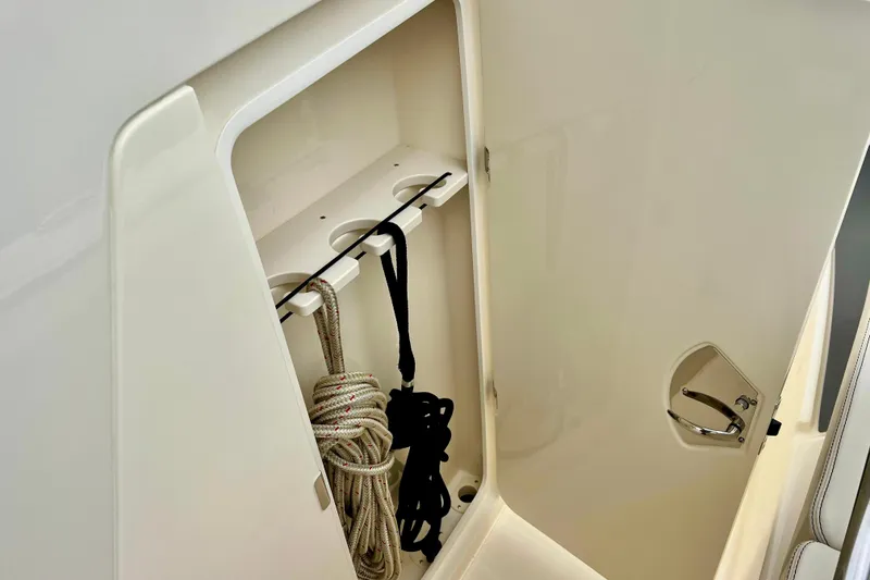 Slide: The Image of 2026 Scout 288 LXF boat storage compartment with ropes and secure latch. - 35