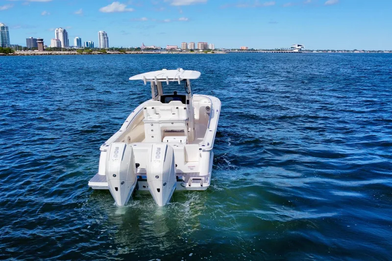 Slide: The Image of 2026 Scout 288 LXF boat cruising on open water near city skyline. - 7