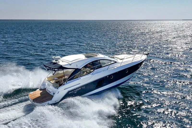 Slide: The Image of 2014 Beneteau Gran Turismo 38 yacht cruising on open water, creating waves. - 19