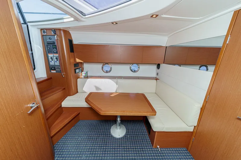 Slide: The Image of Interior of 2014 Beneteau Gran Turismo 38 yacht with cozy seating and wooden table. - 38