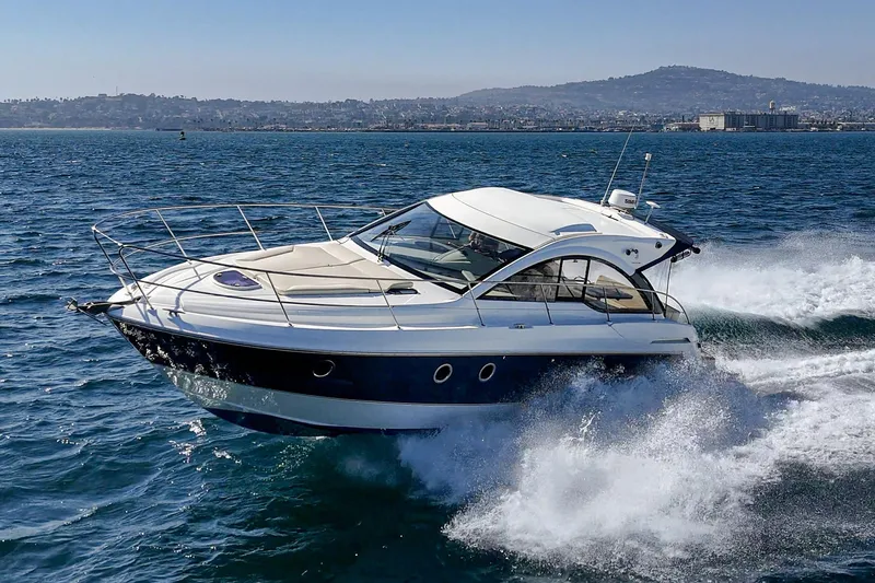 Slide: The Image of 2014 Beneteau Gran Turismo 38 yacht cruising on open water, scenic coastal backdrop. - 4