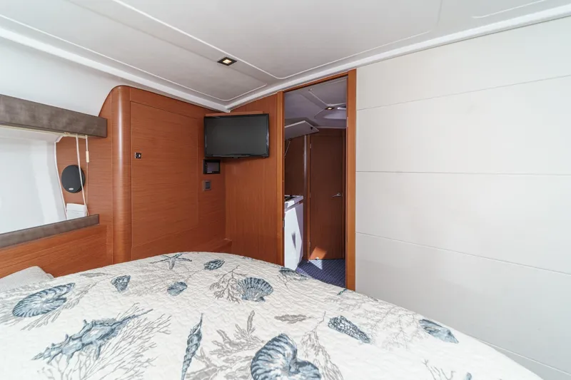 Slide: The Image of 2014 Beneteau Gran Turismo 38 cabin interior with TV and nautical-themed bedding. - 48