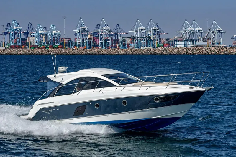 Slide: The Image of 2014 Beneteau Gran Turismo 38 yacht cruising near industrial port cranes. - 6