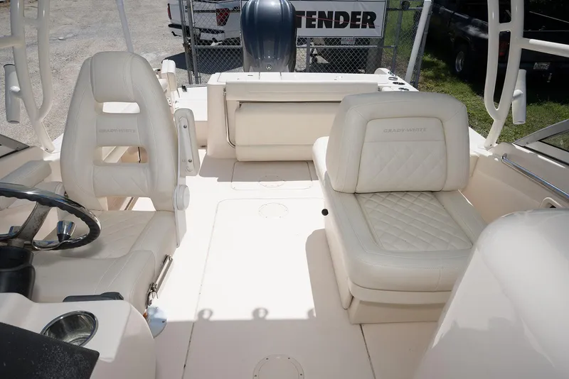 Slide: The Image of 2023 Grady-White Freedom 235 boat interior with white leather seating and steering wheel. - 14