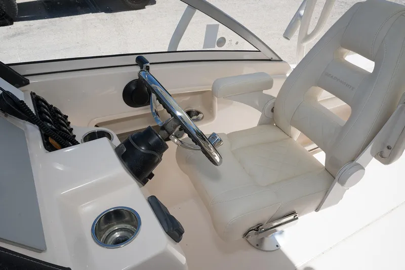 Slide: The Image of 2023 Grady-White Freedom 235 boat helm with white captain's chair and steering wheel. - 16
