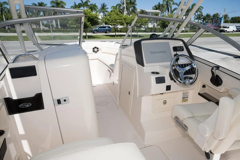 Slide: The Image of 2023 Grady-White Freedom 235 boat interior with Garmin navigation system and steering wheel. - 17