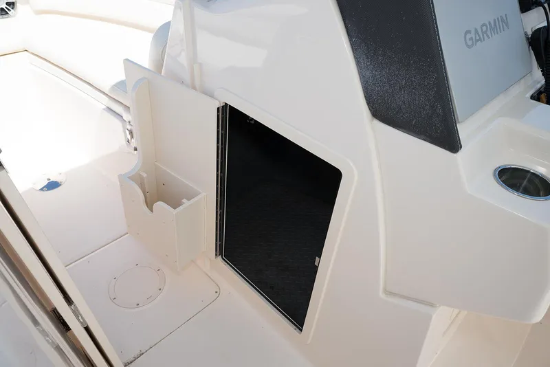 Slide: The Image of 2023 Grady-White Freedom 235 boat interior with storage compartment and Garmin equipment. - 21
