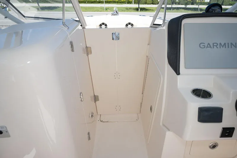 Slide: The Image of 2023 Grady-White Freedom 235 boat interior with Garmin display and storage compartment. - 22