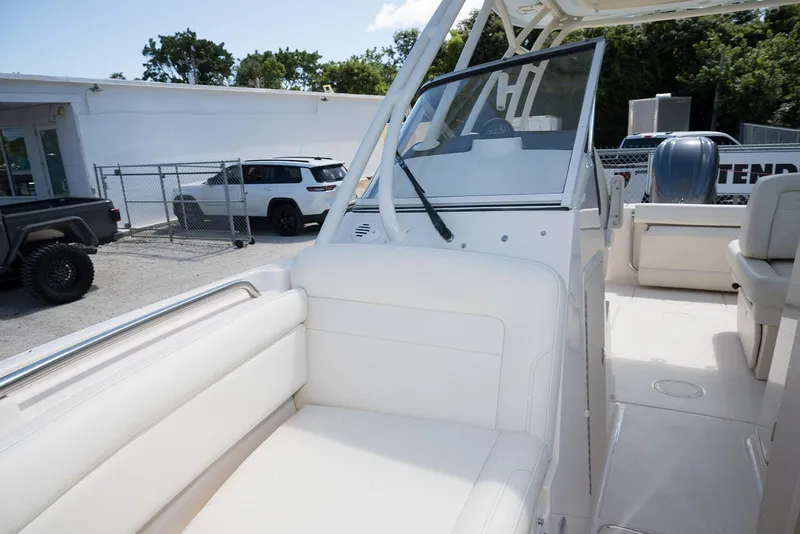 Slide: The Image of 2023 Grady-White Freedom 235 boat interior with seating and windshield, parked outdoors. - 24