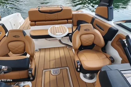 Slide: The Image of 2023 Chaparral 267 SSX boat interior with tan seating and wooden flooring on the water. - 4