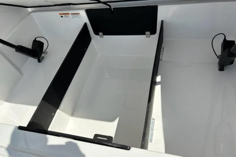 Slide: The Image of 2023 Regal LX4 boat storage compartment with black dividers and hydraulic supports. - 14