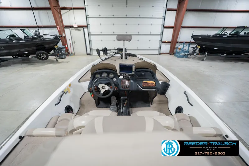Slide: The Image of 2003 Nitro 911 CDC boat interior with trolling motor and seating in a garage. - 15
