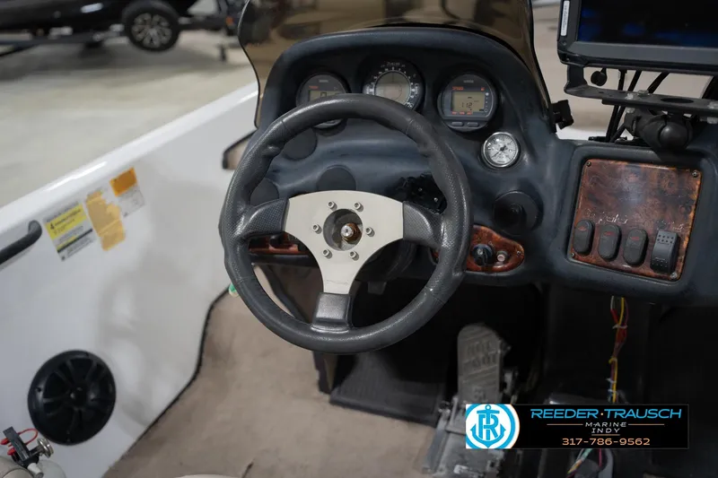 Slide: The Image of Steering wheel of a 2003 Nitro 911 CDC boat, featuring a central hub and dashboard instruments. - 27