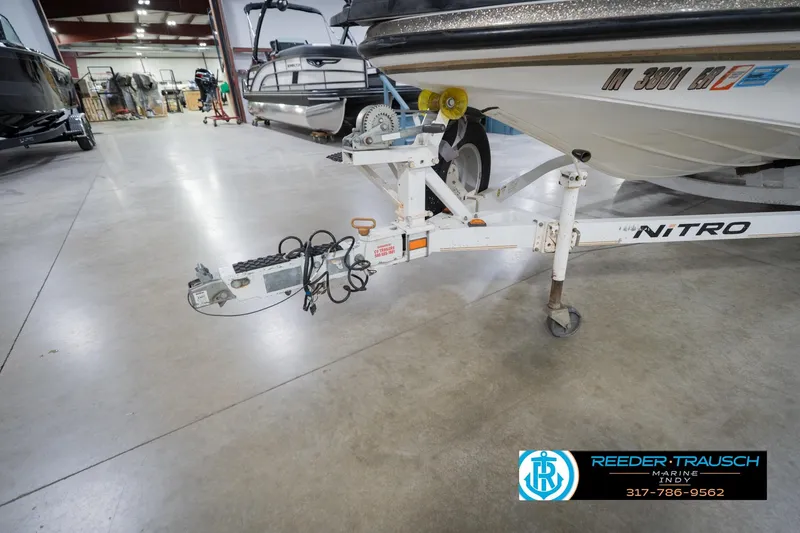 Slide: The Image of 2003 Nitro 911 CDC boat trailer with logo in a showroom setting. - 56