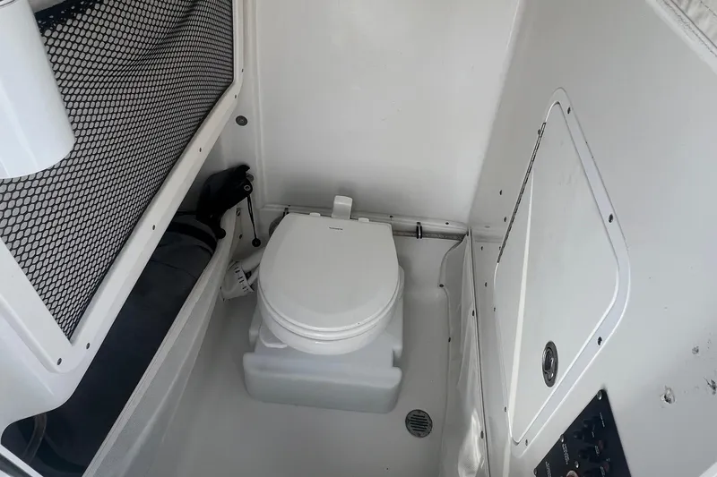 Slide: The Image of 2019 Sea Hunt Gamefish 25 boat interior with portable toilet and storage net. - 11