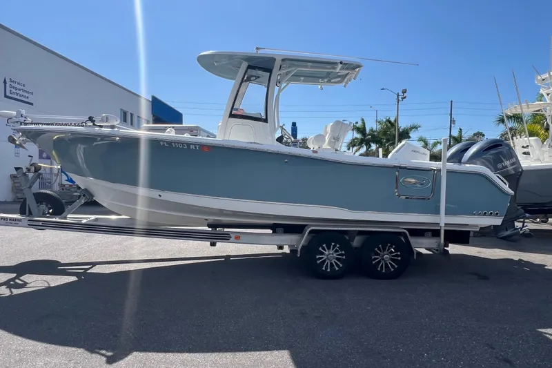 Slide: The Image of 2019 Sea Hunt Gamefish 25 boat on trailer, parked outdoors, sunny day. - 3