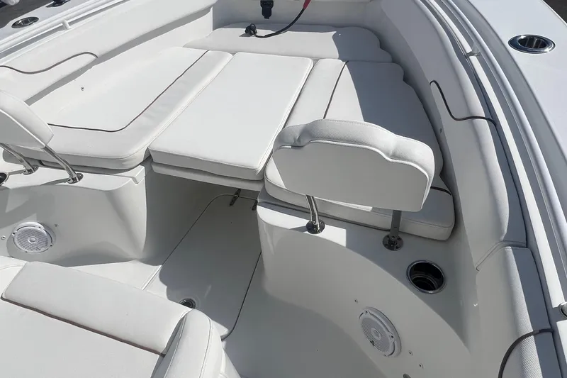 Slide: The Image of 2019 Sea Hunt Gamefish 25 boat interior with white cushioned seating and cup holders. - 9
