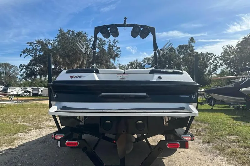 Slide: The Image of 2012 Axis A20 boat rear view with wakeboard tower, parked outdoors. - 2