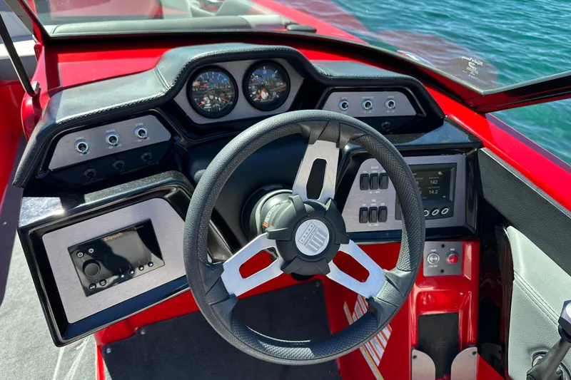 Slide: The Image of 2021 MasterCraft NXT24 boat dashboard with steering wheel and control panels. - 15