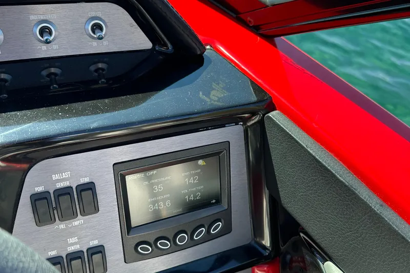 Slide: The Image of 2021 MasterCraft NXT24 dashboard with control panel and digital display on a sunny day. - 16
