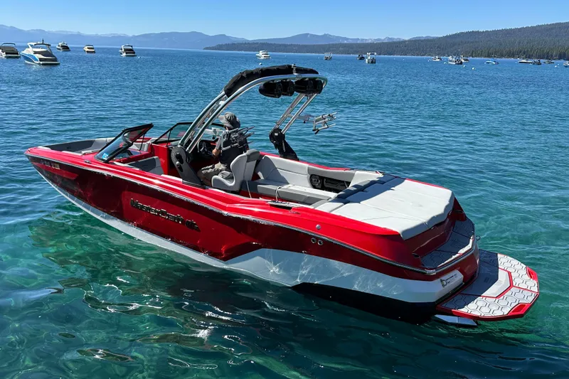 Slide: The Image of 2021 MasterCraft NXT24 boat on clear blue water, surrounded by other boats. - 2